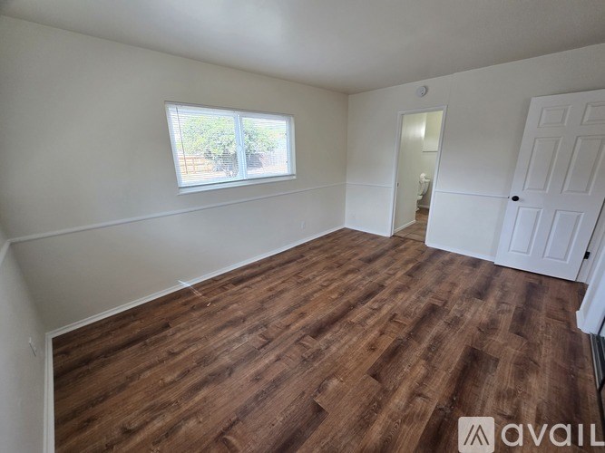 A room with wooden flooring and white walls.