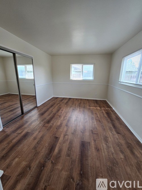 A room with wooden flooring and a window.