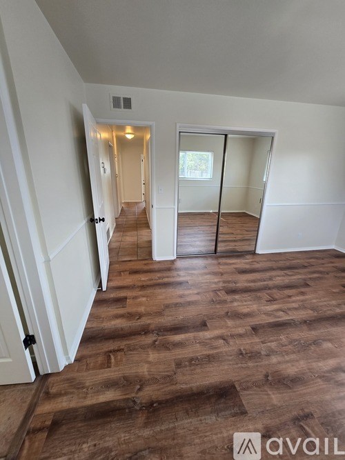 A room with wooden flooring and a sliding glass door.