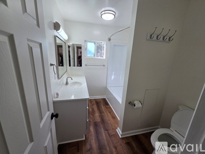 A bathroom with a sink, mirror, and toilet.