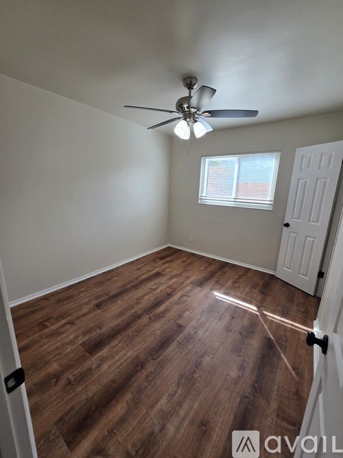 A room with a ceiling fan and a door.