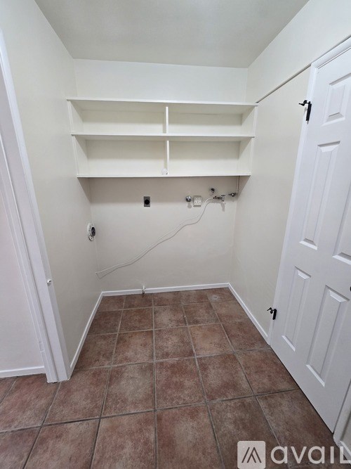 A white closet with a door and shelves.