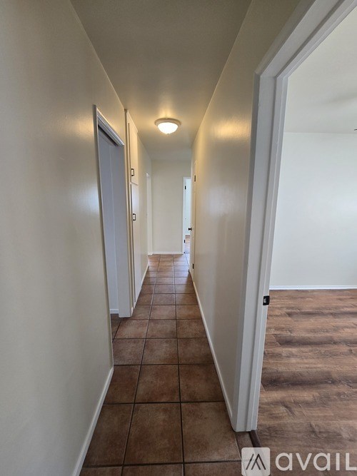 A long hallway with tiled floors and white walls.