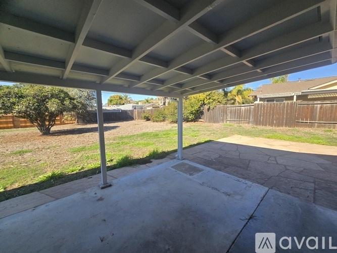 A patio with a white roof and concrete floor.