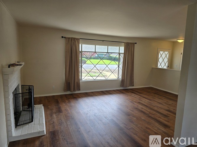 A spacious living room with hardwood floors and a fireplace.