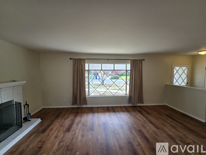 A room with a fireplace and wooden floors.