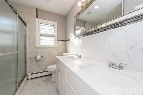 A bathroom with a marble countertop and a walk-in shower.