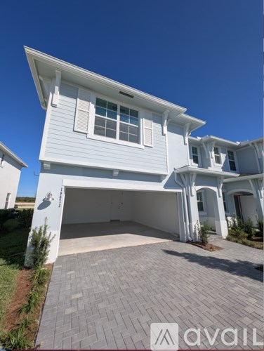 A white house with a garage is for sale.