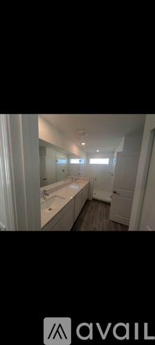 A bathroom with a sink, mirror, and lighting fixtures.