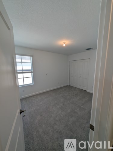 A room with a carpeted floor and a window.