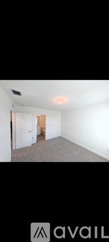 A room with a carpeted floor and a door on the left side.