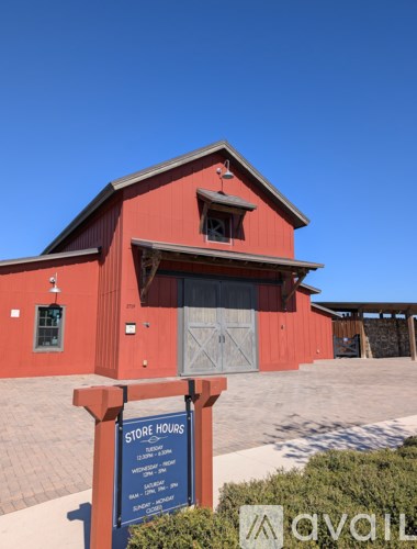 A red building with a sign that says "Store Hours" in front of it.
