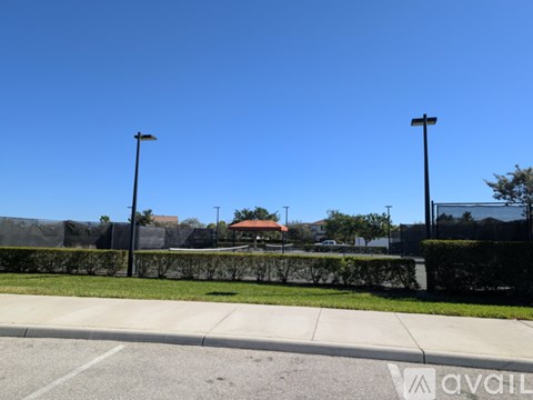 A street view with a clear blue sky and a building in the distance.