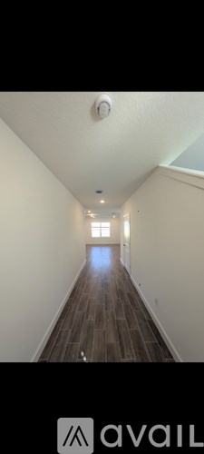 A long hallway with wooden floors and white walls.