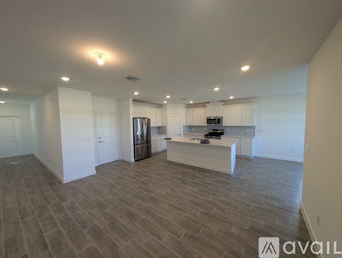 A spacious kitchen with a refrigerator, microwave, and oven.