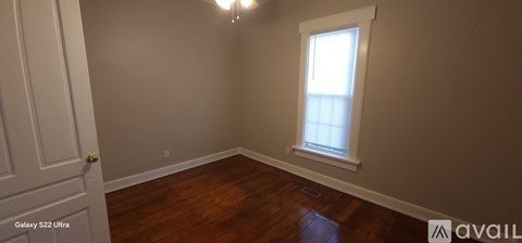 A room with a window and wooden floors is available.