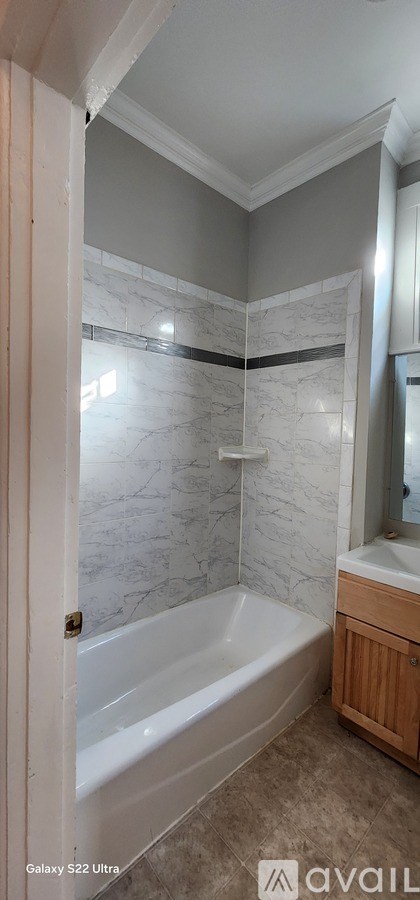 A bathroom with a bathtub and a mirror.