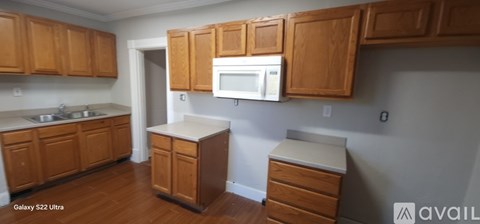 A kitchen with wooden cabinets and a white microwave.