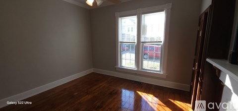 A room with a window and wooden floors.