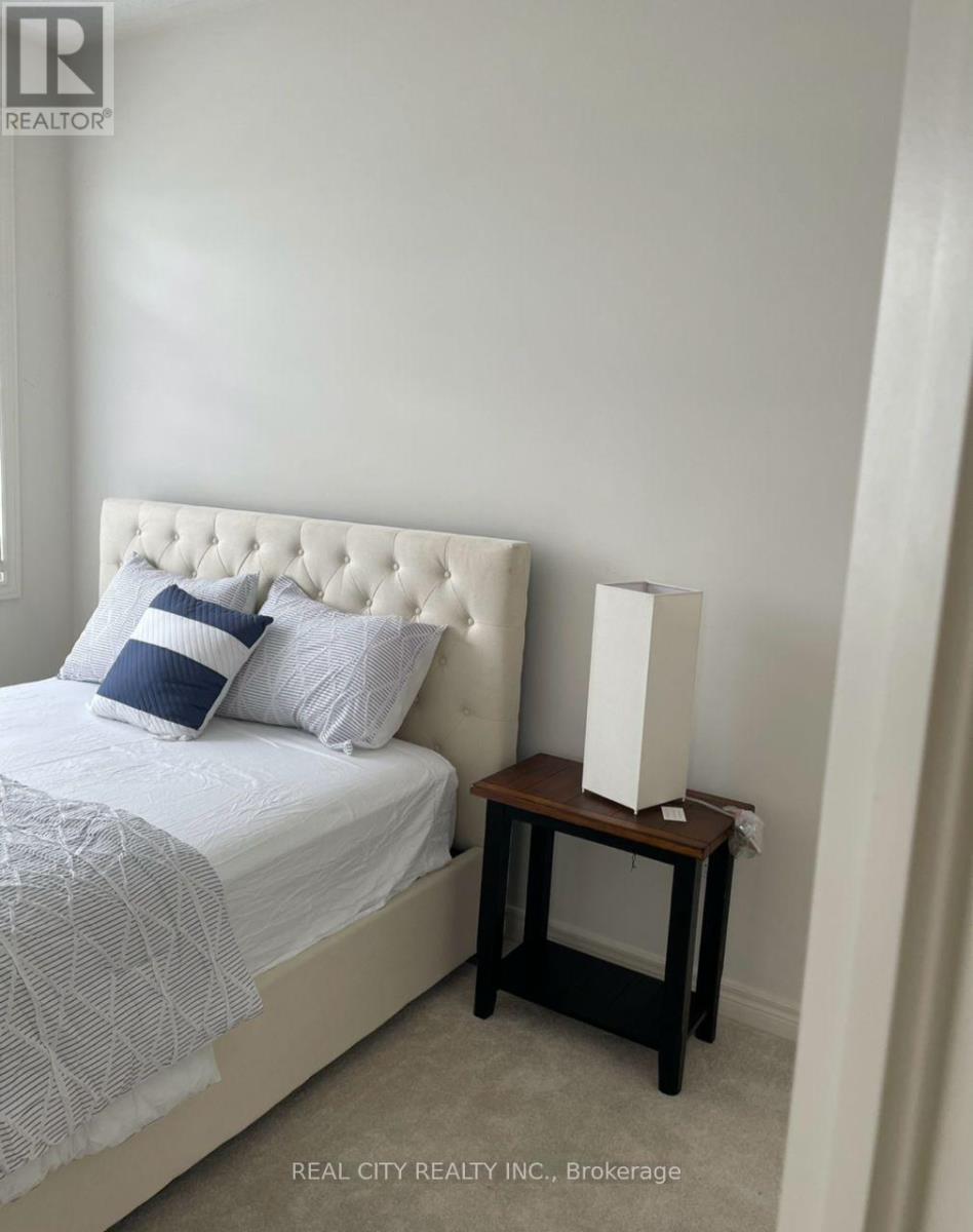 A bedroom with a white bed and a small wooden table.