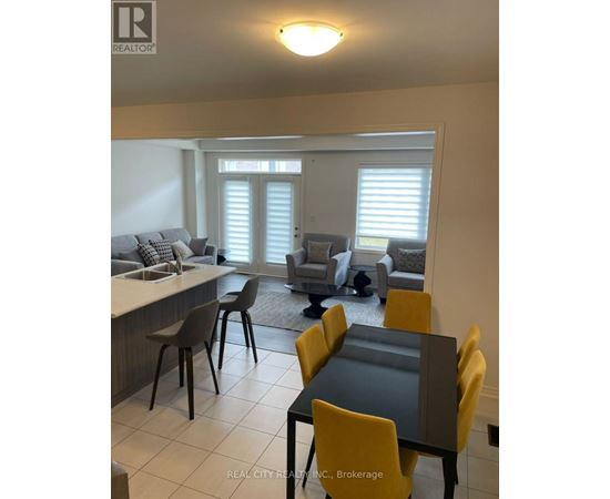 A dining room with a table and chairs.