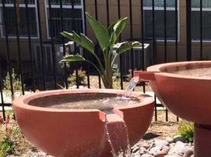 three water fountains in a garden with rocks