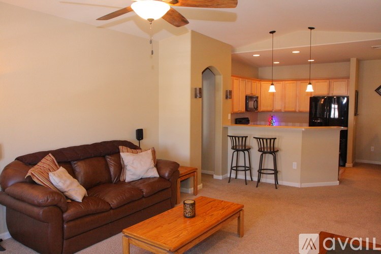 A living room with a brown couch and a wooden coffee table.