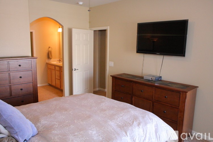A bedroom with a bed, dresser, and television.