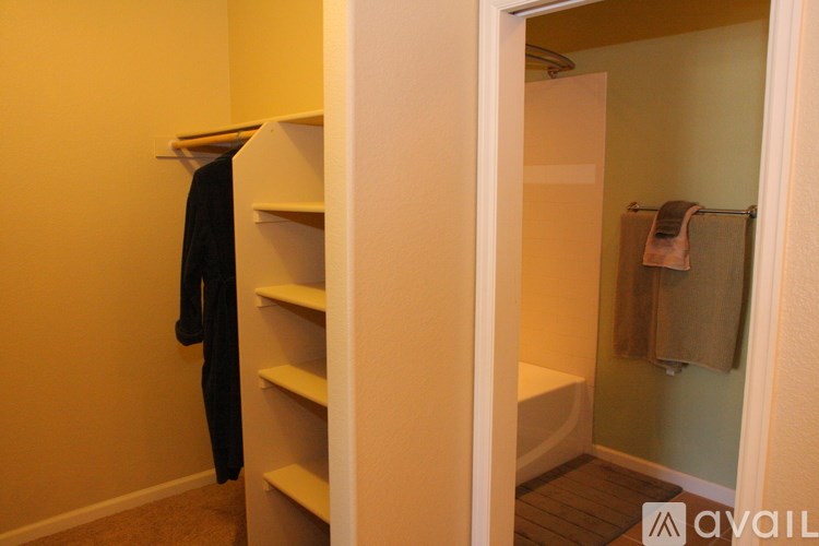 A bathroom with a towel hanging on the wall and a towel rack with a towel on it.