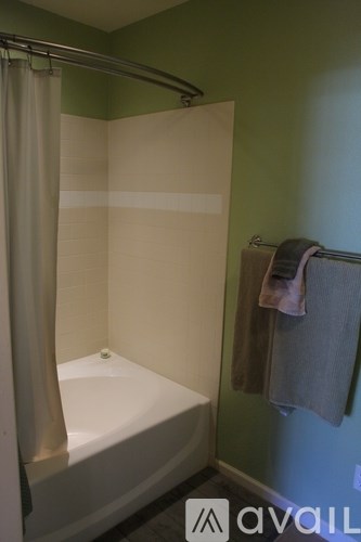 A bathroom with a white tub and a towel hanging on the wall.