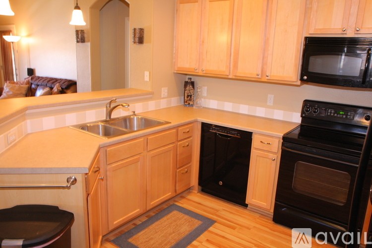 A kitchen with wooden cabinets and a black oven.