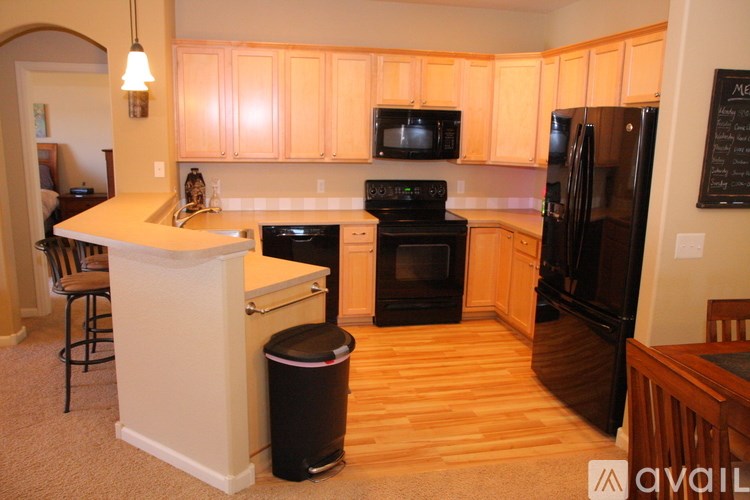 A kitchen with wooden cabinets and black appliances.