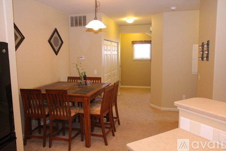 A dining room with a wooden table and chairs.
