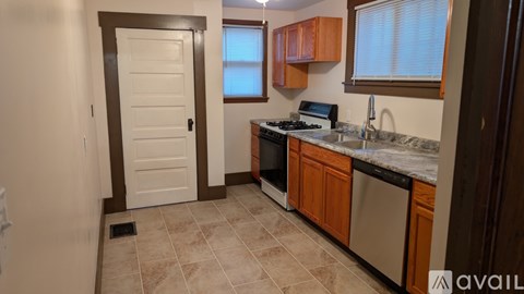 A kitchen with a white door and brown cabinets.