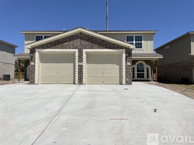 A house with a garage and a driveway in front.