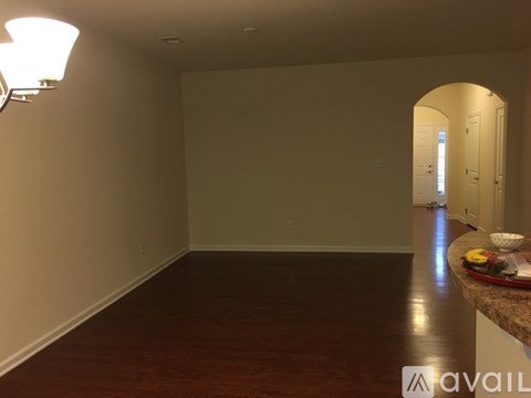 A room with a wooden floor and a light on the wall.