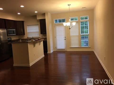 A kitchen with dark wood cabinets and a black refrigerator.