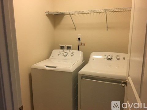 Two white washing machines in a small laundry room.