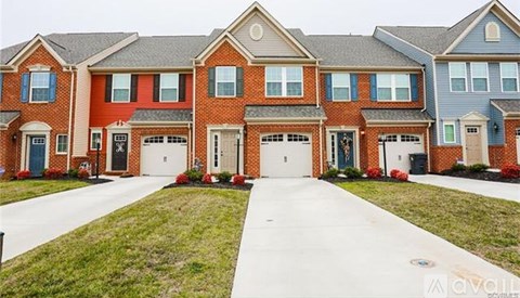 A row of houses with a white driveway in front.