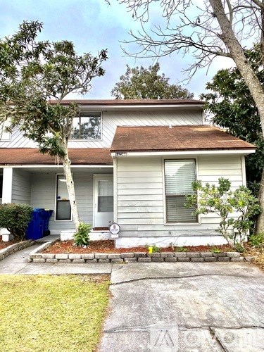 A house with a grey siding and a brown roof.