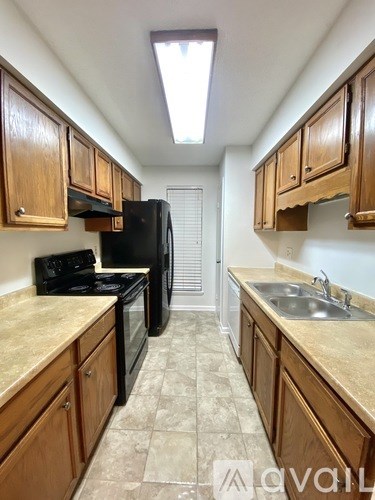 A kitchen with wooden cabinets and black appliances.