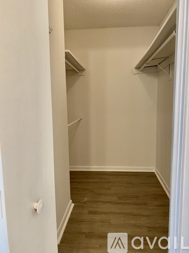 A white hallway with wood flooring and white walls.