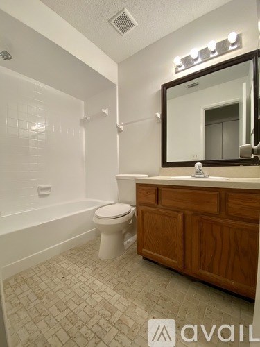 A bathroom with a toilet, sink, and mirror.