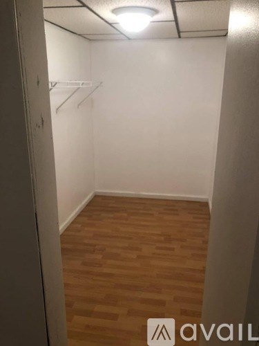 A room with wooden flooring and white walls.