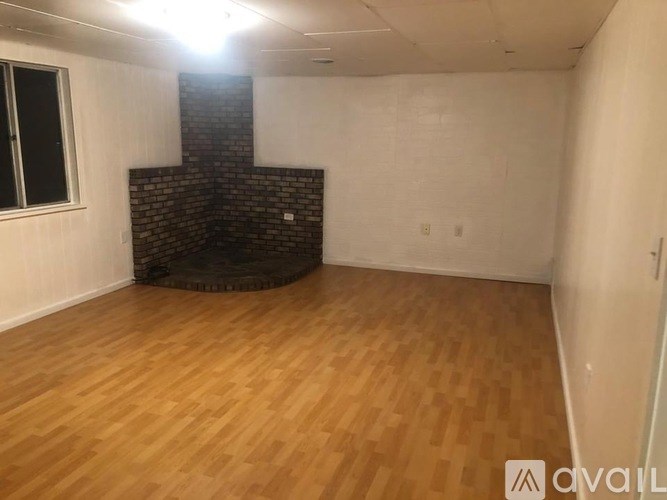 A room with wooden flooring and a brick chimney.