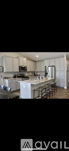 A modern kitchen with white cabinets and stainless steel appliances.