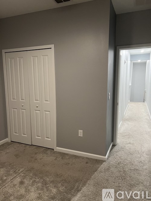 A white door is in a room with grey walls.
