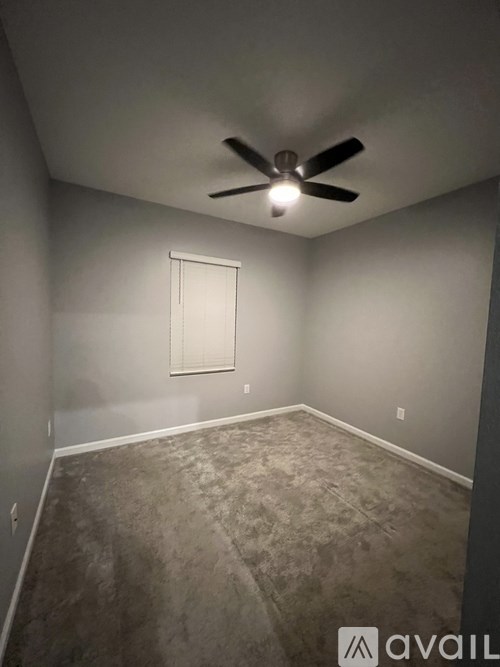 A room with a ceiling fan and a window.