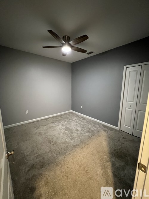 A room with a ceiling fan and a door.