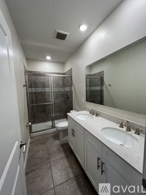 A bathroom with a toilet, sink, and mirror.